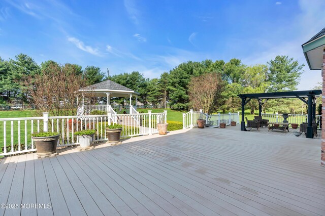 wooden terrace with a lawn and a gazebo