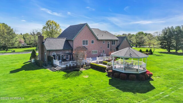 back of house with a yard, a gazebo, a chimney, and a deck