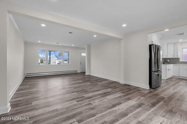 unfurnished living room featuring ornamental molding, a baseboard radiator, visible vents, and wood finished floors