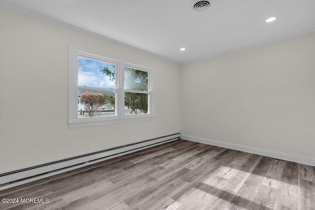 spare room featuring wood finished floors, visible vents, recessed lighting, a baseboard radiator, and crown molding