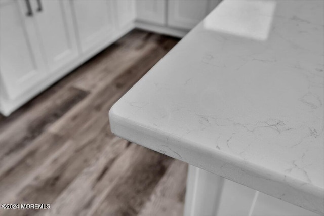 interior details with dark wood-style flooring and white cabinets