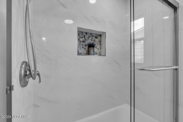 bathroom with shower / bath combination with glass door