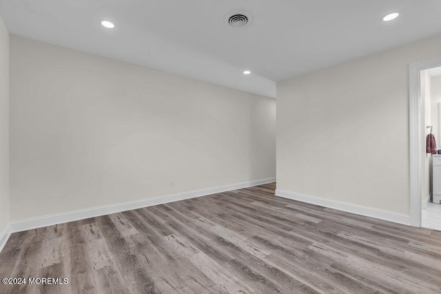 spare room featuring baseboards, recessed lighting, visible vents, and wood finished floors
