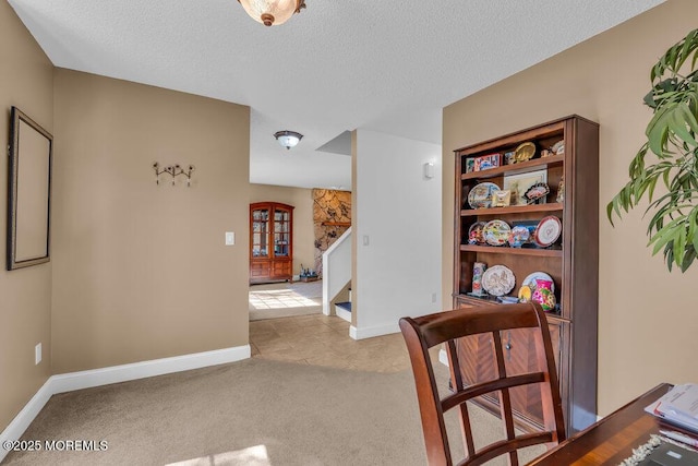 hall with stairs, baseboards, light colored carpet, a textured ceiling, and light tile patterned floors
