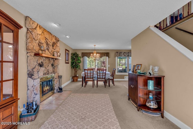 interior space featuring a textured ceiling, baseboards, an inviting chandelier, and light carpet