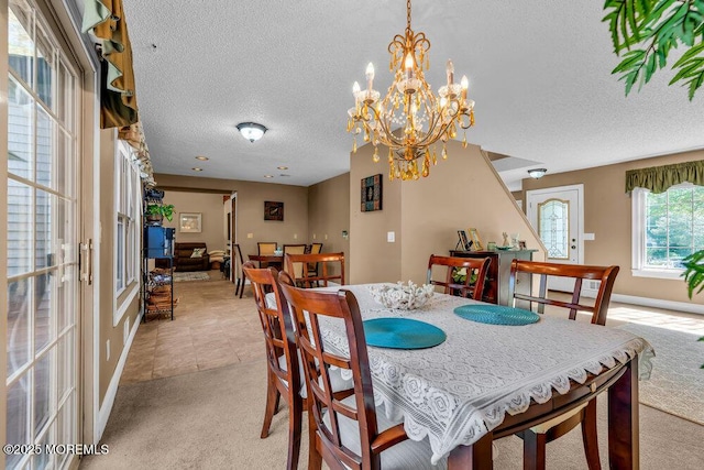 dining area featuring a textured ceiling, light colored carpet, baseboards, an inviting chandelier, and light tile patterned flooring