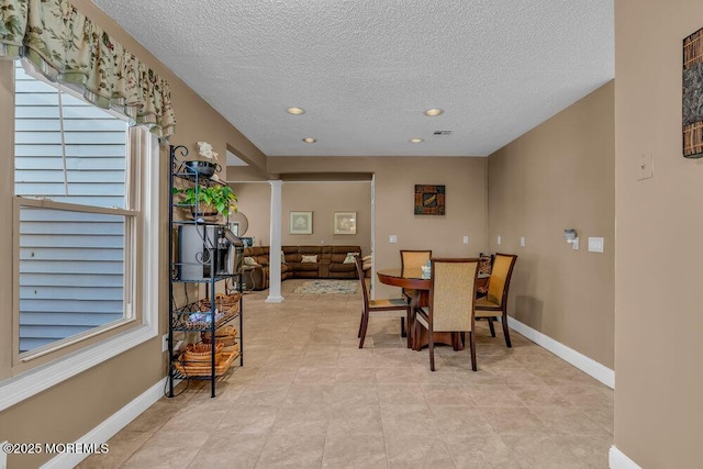 dining room with recessed lighting, baseboards, ornate columns, and a textured ceiling
