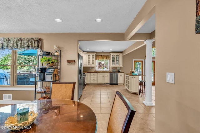 dining area with light tile patterned flooring, a textured ceiling, recessed lighting, ornate columns, and visible vents