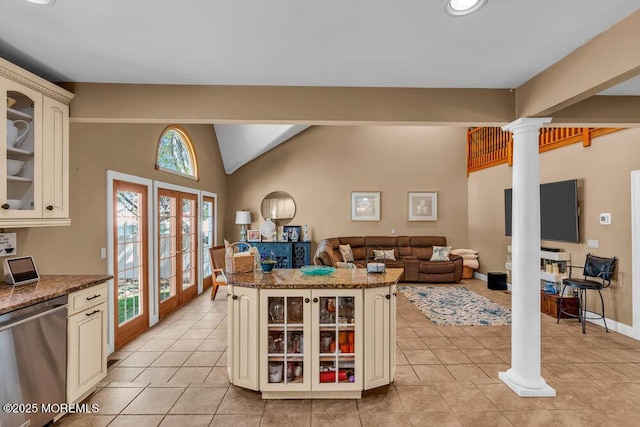kitchen with cream cabinets, vaulted ceiling, dishwasher, glass insert cabinets, and ornate columns