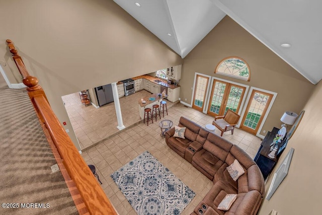 living area featuring tile patterned flooring, recessed lighting, baseboards, and high vaulted ceiling