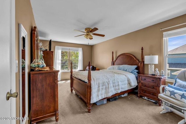 bedroom with a ceiling fan and light carpet