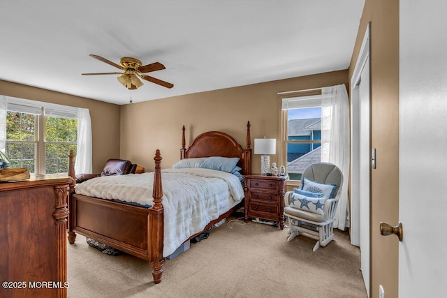 bedroom with a closet, a ceiling fan, and light colored carpet