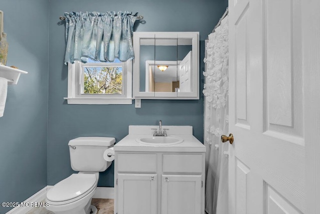 bathroom with toilet, baseboards, and vanity
