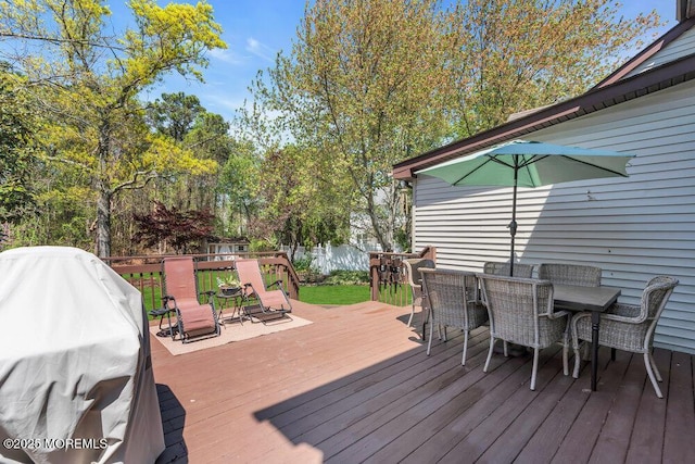 wooden terrace with outdoor dining space and a grill