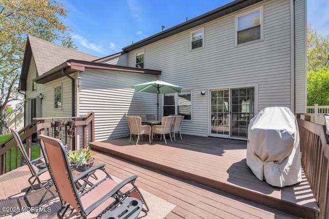 deck with grilling area and outdoor dining space