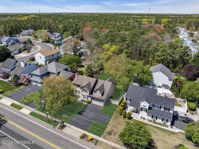 birds eye view of property featuring a residential view and a wooded view
