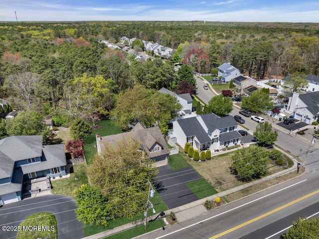 bird's eye view featuring a residential view and a wooded view
