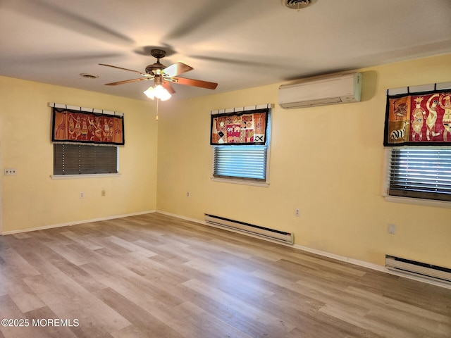 spare room with ceiling fan, a wall mounted air conditioner, baseboards, wood finished floors, and a baseboard radiator