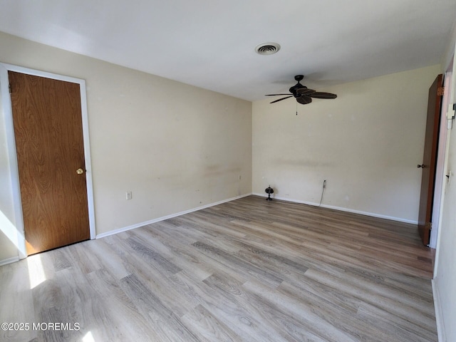empty room featuring visible vents, baseboards, ceiling fan, and light wood-type flooring