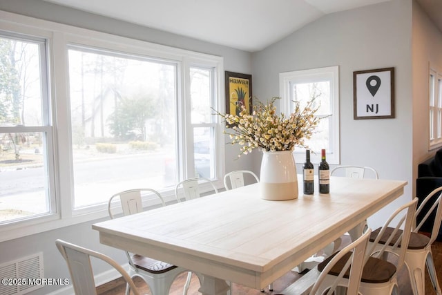 dining space with lofted ceiling and wood finished floors