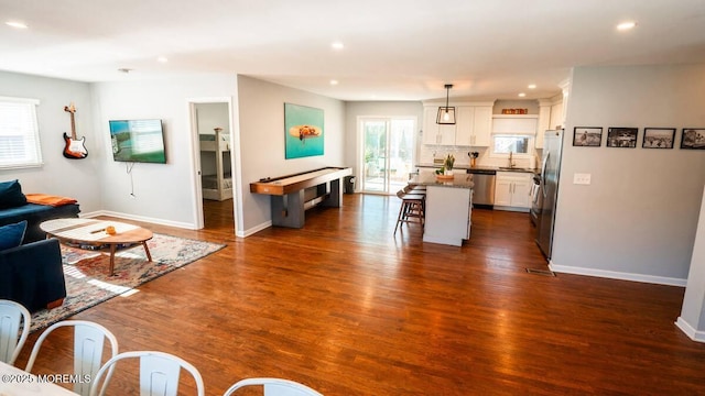 living area featuring plenty of natural light, recessed lighting, baseboards, and dark wood-style floors