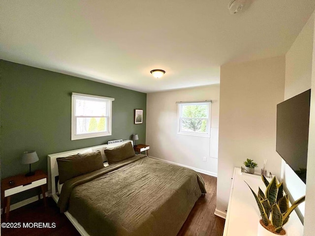 bedroom featuring dark wood-style floors and baseboards