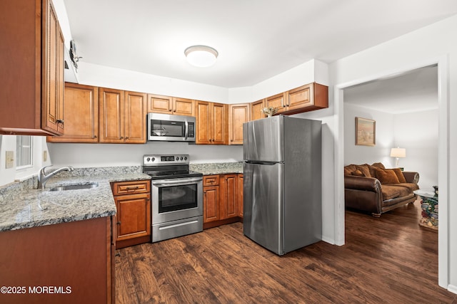 119B Buckingham Dr, Lakewood, NJ 08701 - kitchen with light stone counters, a sink, brown cabinetry, and appliances with stainless steel finishes