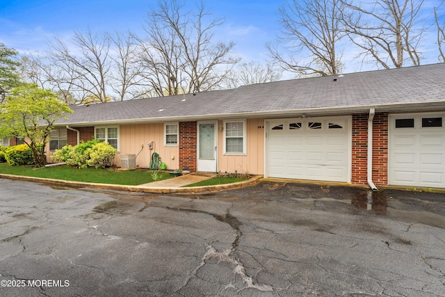 119B Buckingham Dr, Lakewood, NJ 08701 - ranch-style house featuring an attached garage, aphalt driveway, board and batten siding, and roof with shingles