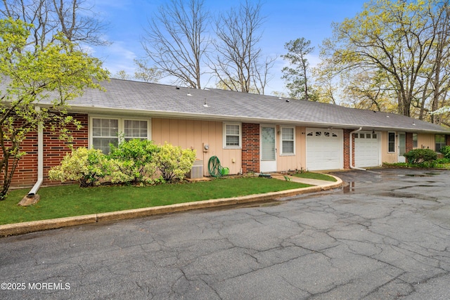119B Buckingham Dr, Lakewood, NJ 08701 - ranch-style house with board and batten siding, driveway, brick siding, central AC, and an attached garage