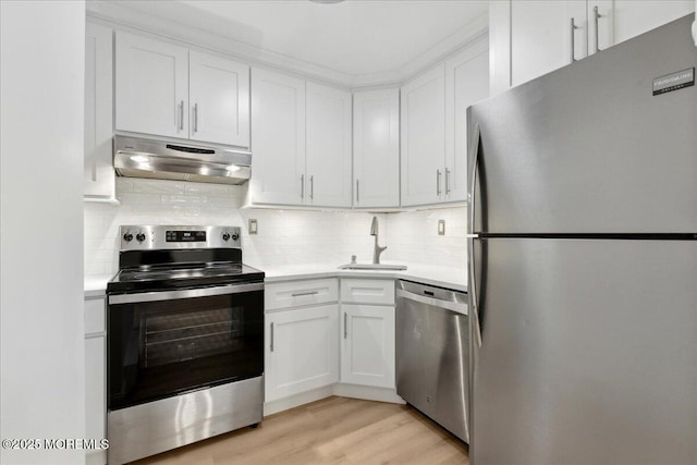 87 Arrowood Rd Unit D, Manalapan, NJ 07726 - kitchen with light countertops, white cabinetry, under cabinet range hood, a sink, and stainless steel appliances