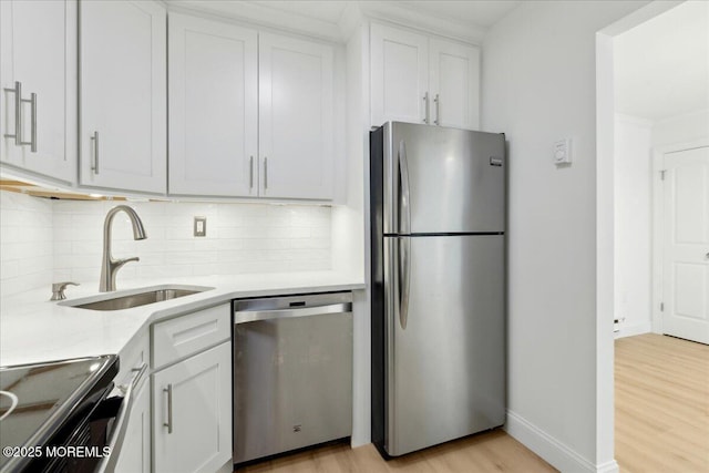 87 Arrowood Rd Unit D, Manalapan, NJ 07726 - kitchen featuring white cabinets, a sink, light wood-style flooring, backsplash, and stainless steel appliances