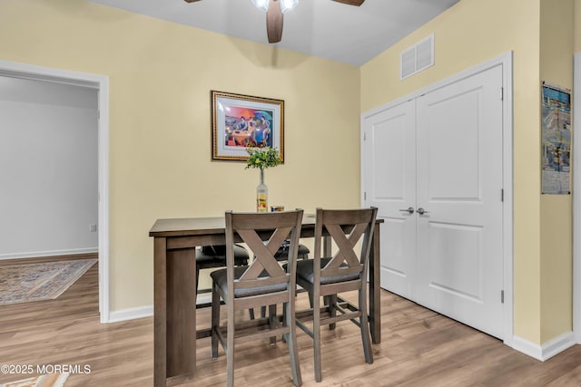 dining room with visible vents, a ceiling fan, baseboards, and light wood-style floors