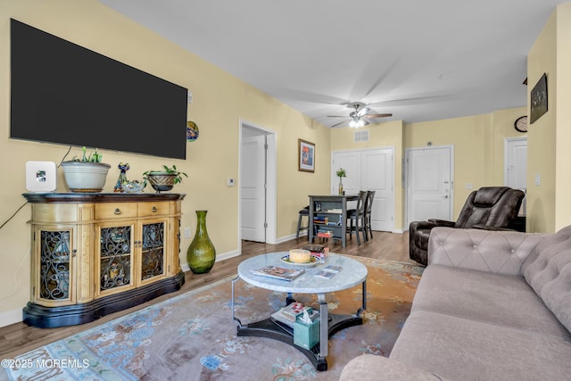 living room featuring baseboards, ceiling fan, wood finished floors, and visible vents