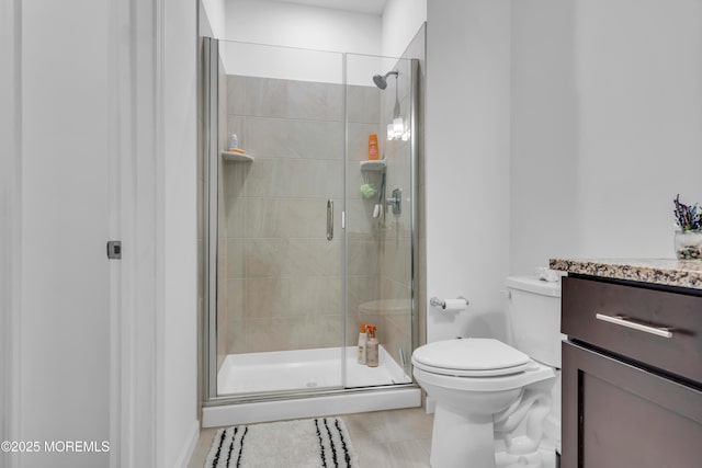 full bath featuring vanity, tile patterned floors, toilet, and a shower stall