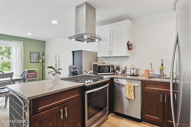 103 Carr Ave, Keansburg, NJ 07734 - kitchen featuring stainless steel appliances, island exhaust hood, light wood-style floors, white cabinets, and a peninsula
