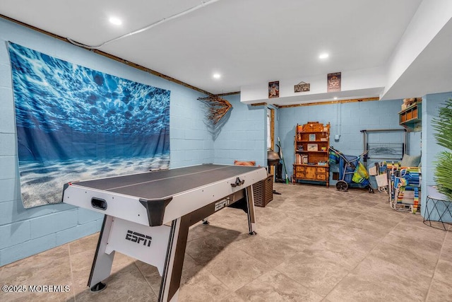 game room with concrete block wall