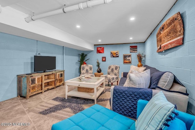 living room with concrete block wall and tile patterned floors