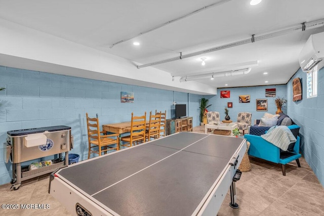 recreation room with concrete block wall, track lighting, tile patterned floors, and a wall mounted air conditioner