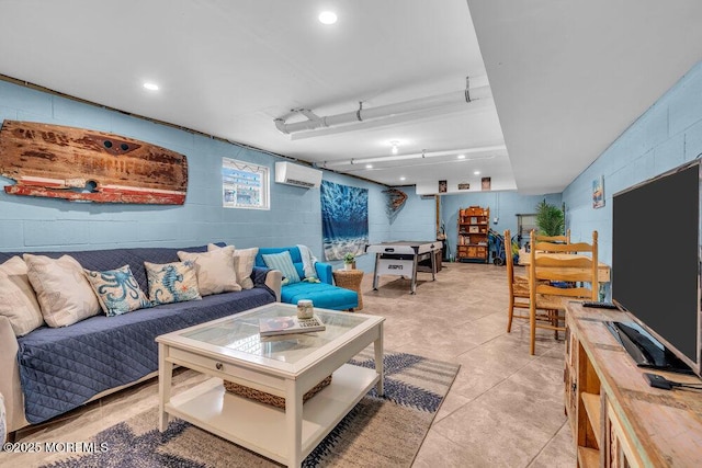 living area with a wall mounted air conditioner, light tile patterned floors, and concrete block wall