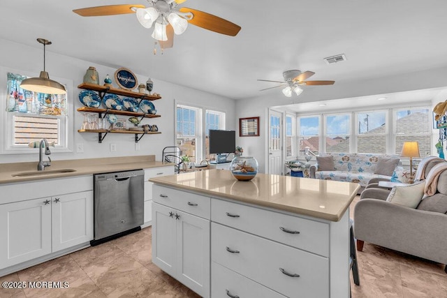 kitchen featuring ceiling fan, visible vents, dishwasher, a sink, and open floor plan