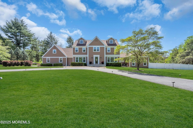 63 Carriage Hill Dr, Colts Neck, NJ 07722 - view of front of house with fence, curved driveway, and a front lawn