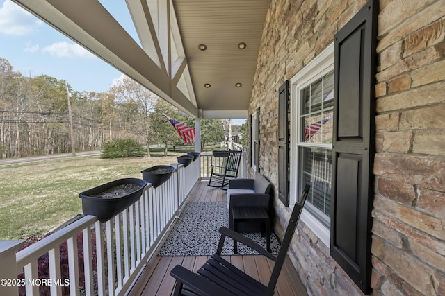 wooden deck featuring a yard and covered porch