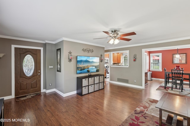 foyer entrance featuring visible vents, ornamental molding, wood finished floors, baseboards, and ceiling fan