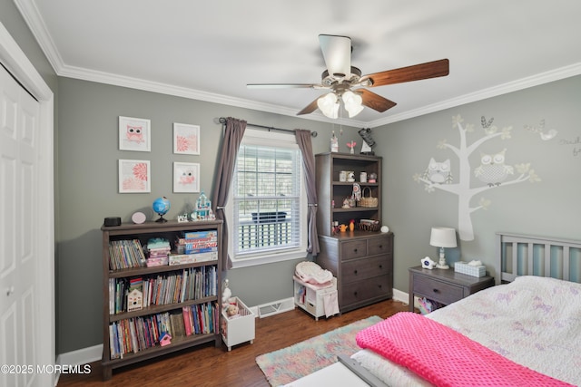 bedroom featuring a closet, ornamental molding, baseboards, and wood finished floors