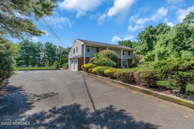 1 Flintlock Rd, Freehold, NJ 07728 - view of property exterior featuring brick siding, a garage, and aphalt driveway