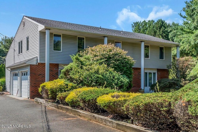 1 Flintlock Rd, Freehold, NJ 07728 - view of front of home with a garage, aphalt driveway, and brick siding