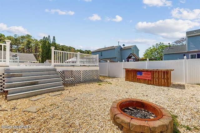 view of yard featuring an outdoor fire pit, fence, and a wooden deck