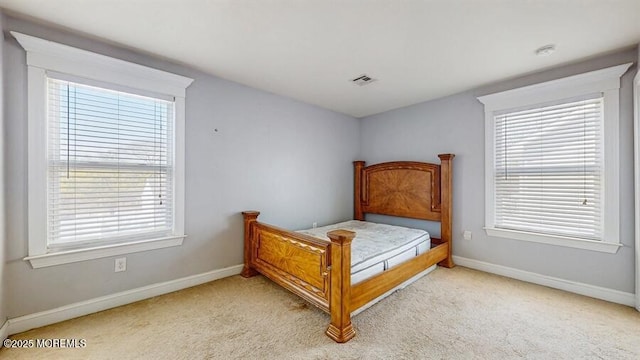 bedroom with light colored carpet, baseboards, and visible vents
