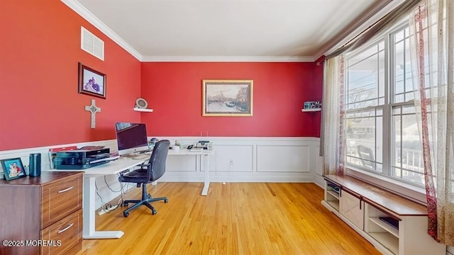 office with a healthy amount of sunlight, a wainscoted wall, crown molding, and visible vents