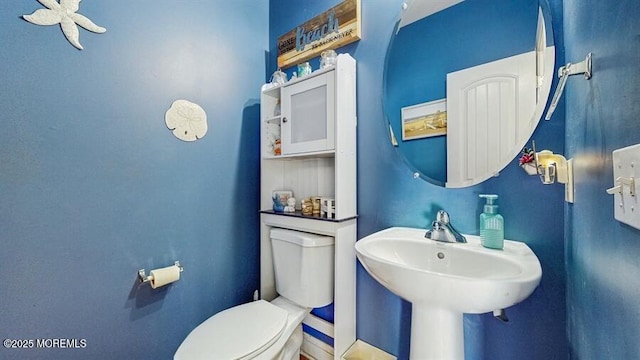 half bathroom featuring toilet and a sink